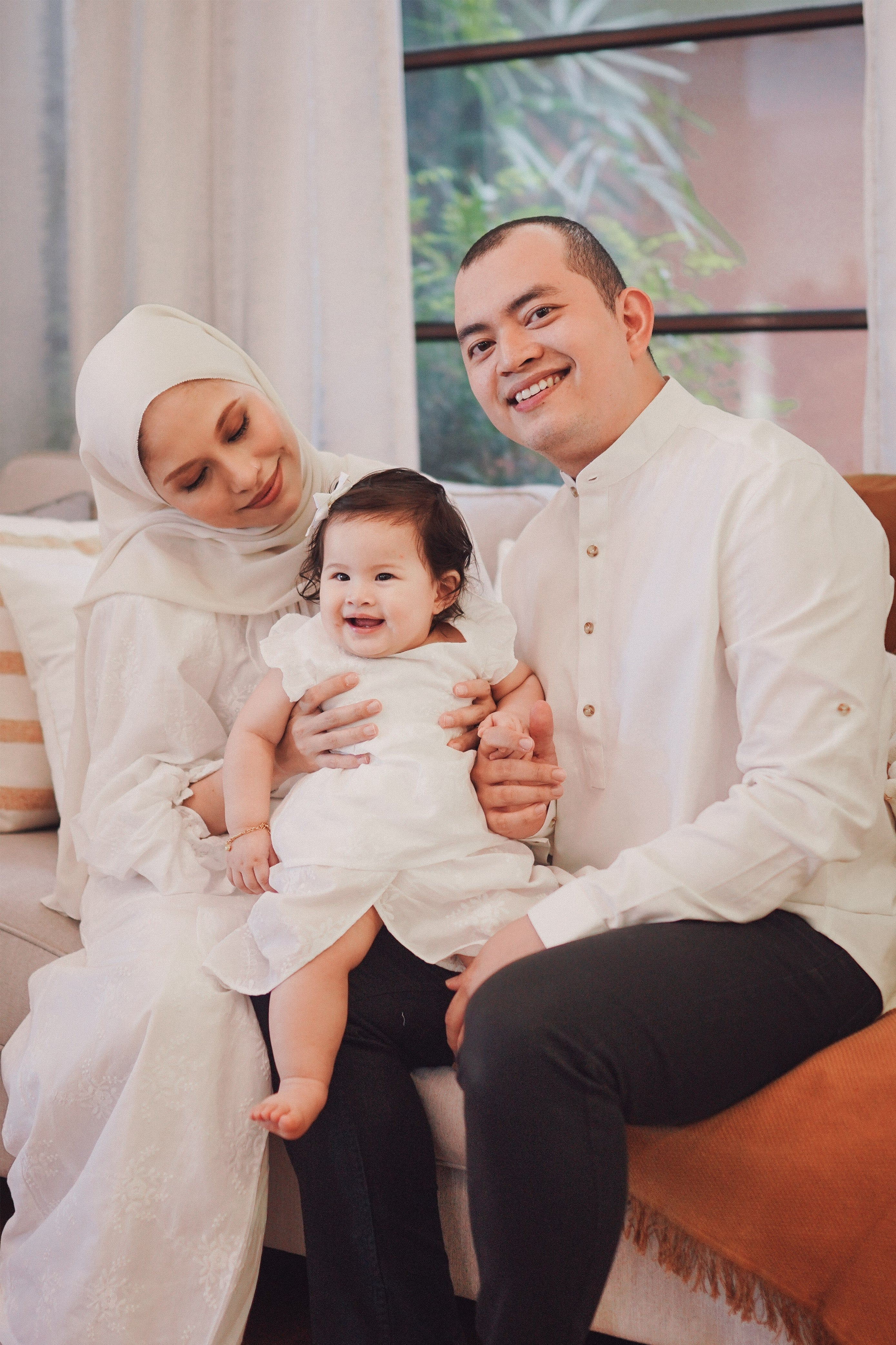 Happy family wearing matching white tops and posing for the camera
