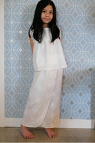 Little girl wearing white dress with a blue background