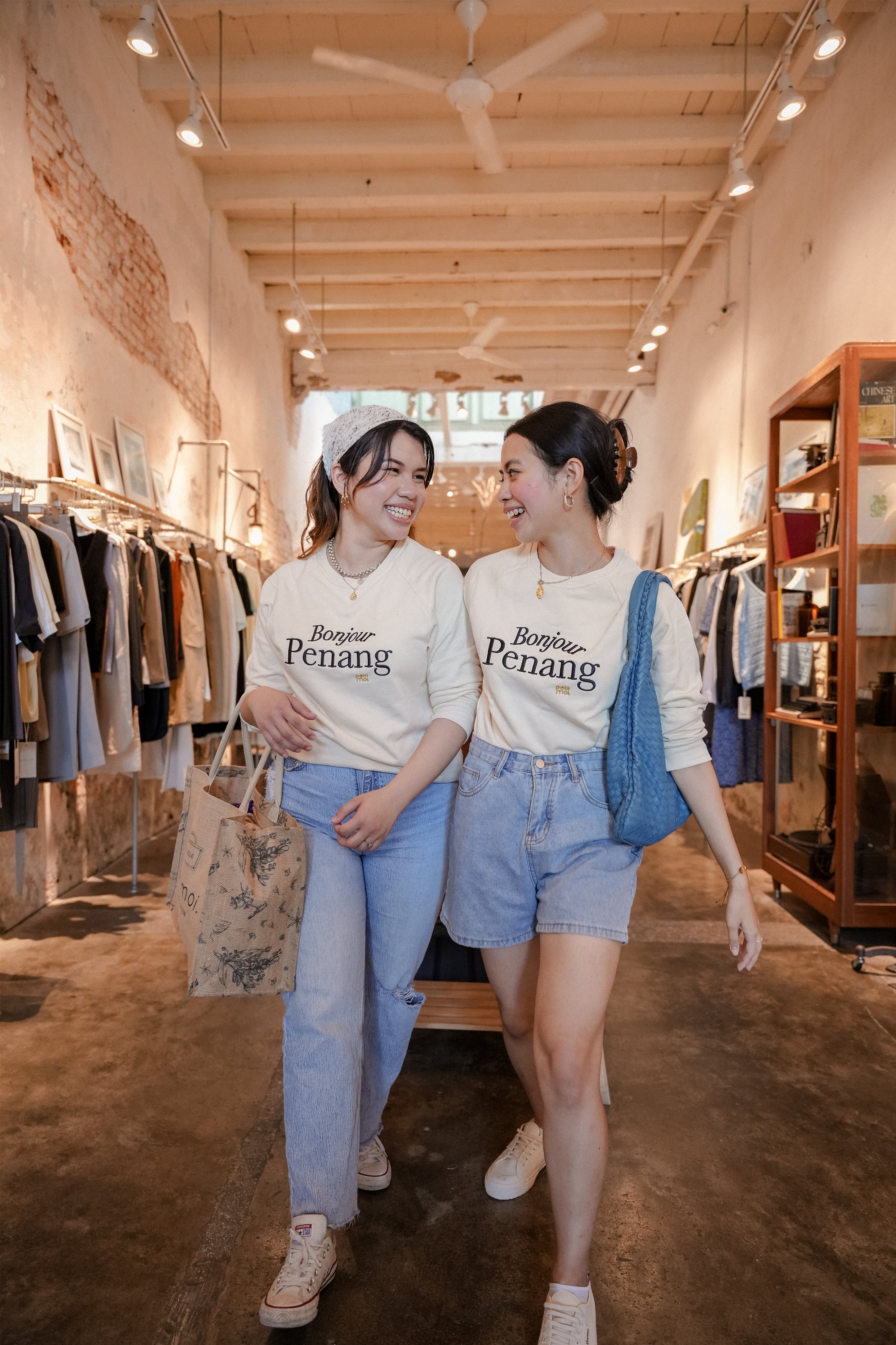 two female models smiling in petit moi jumper
