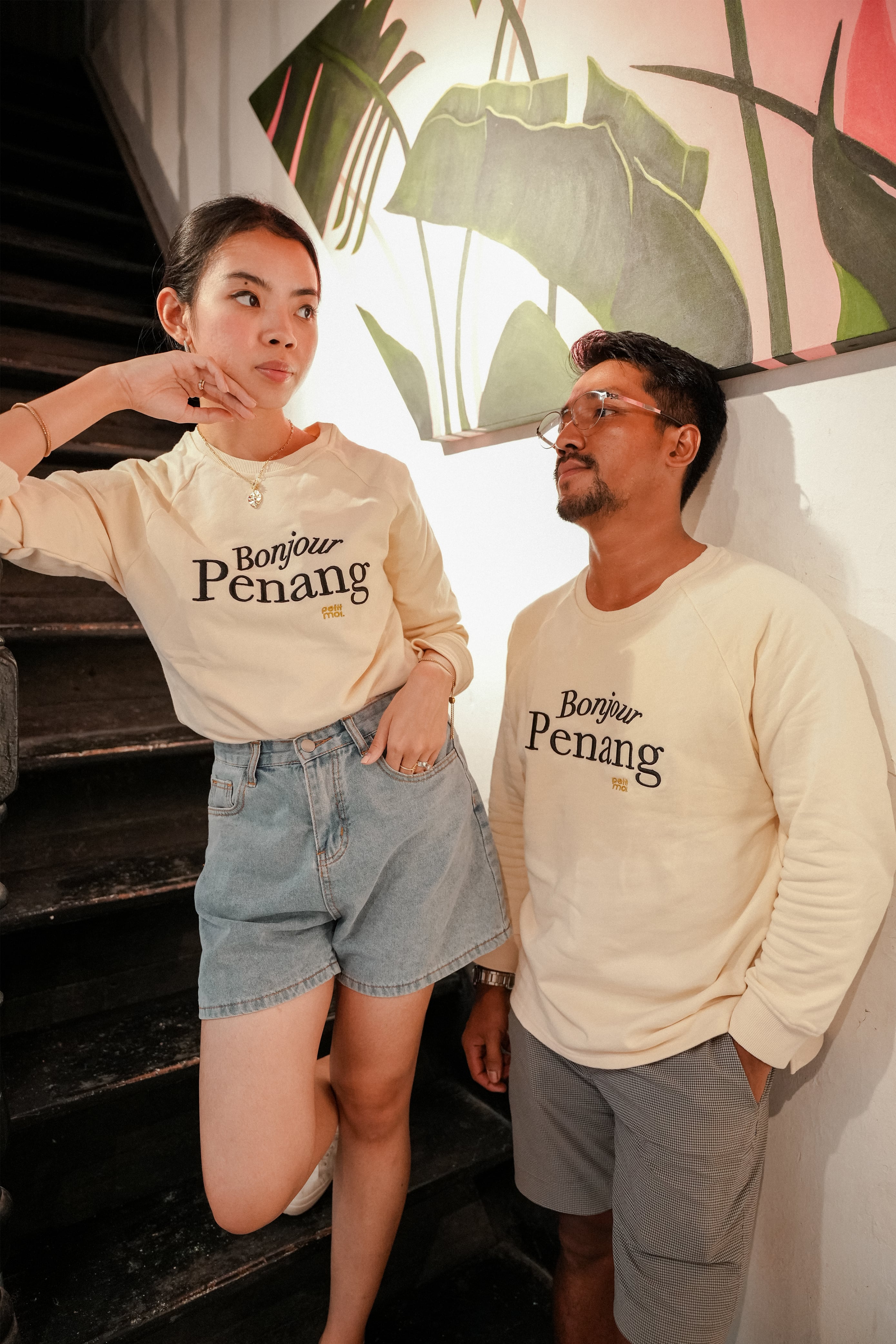 two models wearing petit moi jumper and posing by the stairs