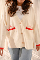 closeup shot of female model in high quality white and red cardigan made by petit moi