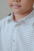 close up shot of little boy in high quality white striped shirt made by petit moi