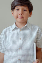 little boy in high quality white striped shirt made by petit moi