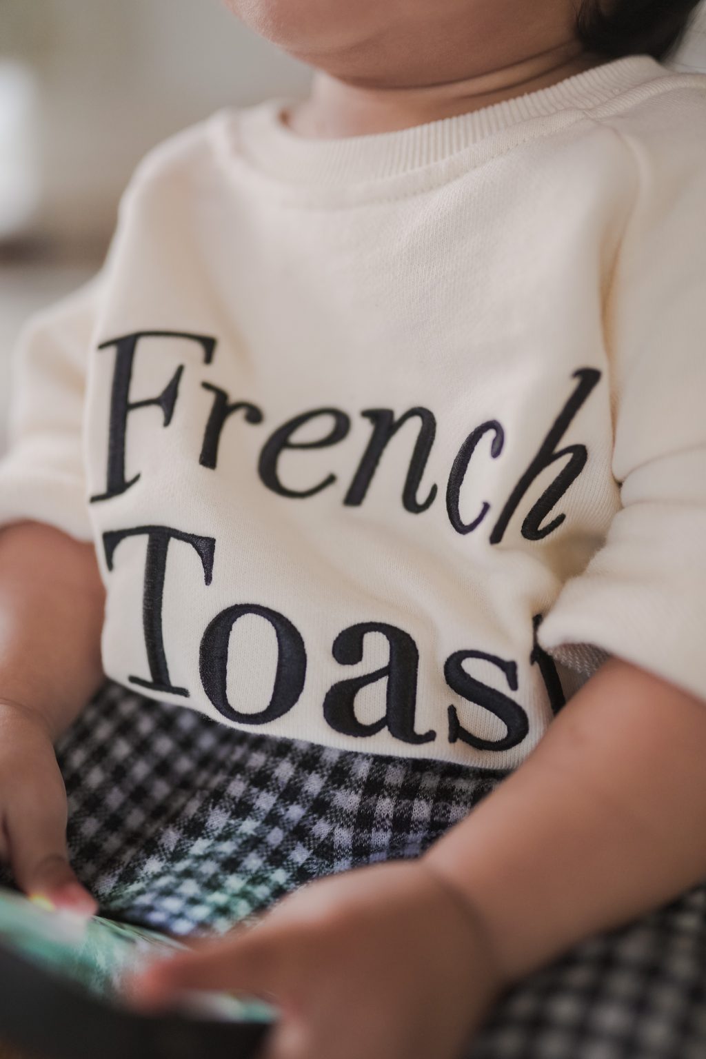 Closeup shot of little girl wearing a high quality sweater made by petit moi