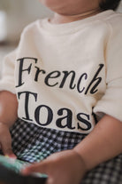 Closeup shot of little girl wearing a high quality sweater made by petit moi