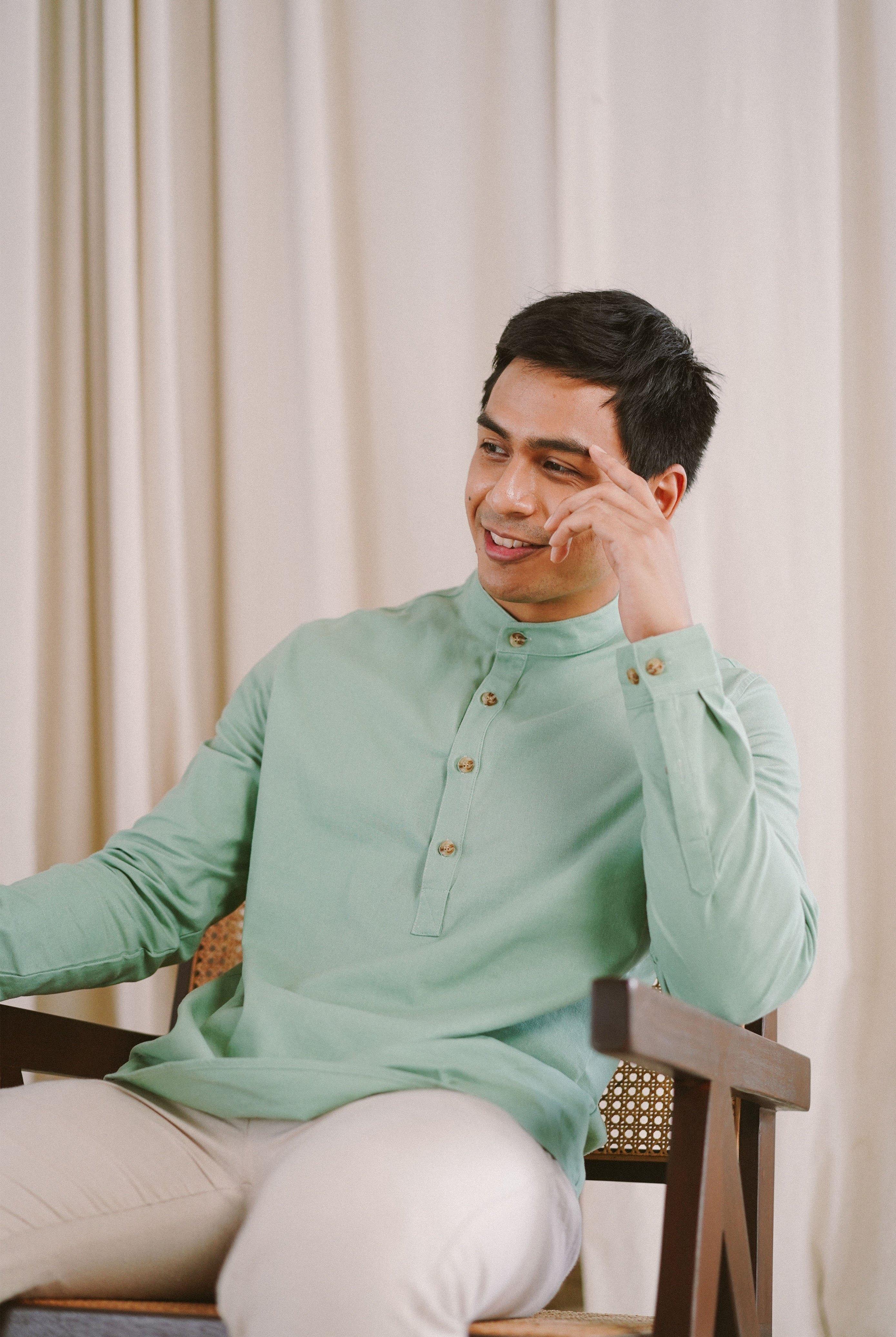 male model sitting down in green kurta by Petit Moi