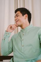 male model sitting down and wearing green kurta by Petit Moi