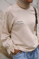 Closeup shot of beige jumper designed by petit moi