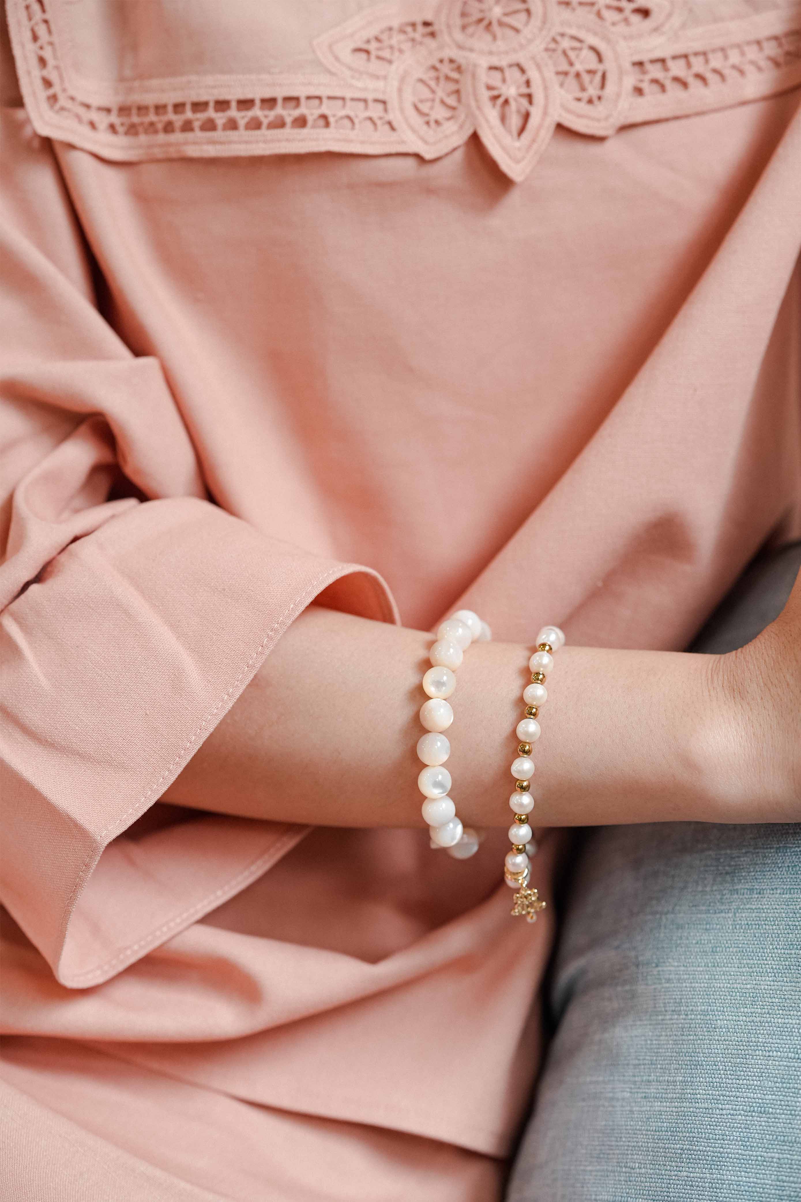 Female model wearing high quality pink baju kurung and bracelets made by petit moi
