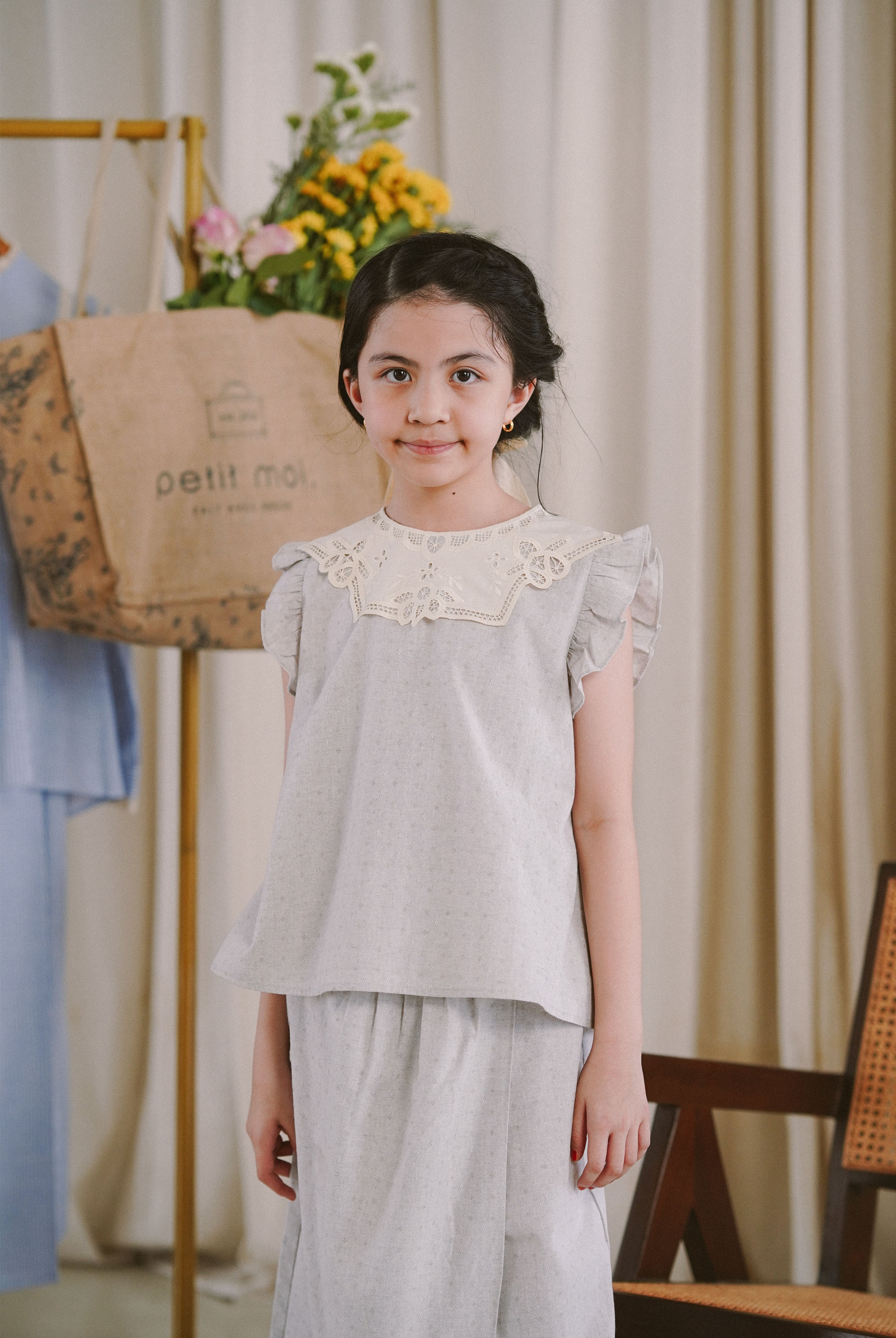 Little girl wearing her favourite light blue dress by petit moi