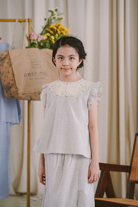 Little girl wearing her favourite light blue dress by petit moi