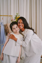 sisters wearing matching light blue dresses made by petit moi