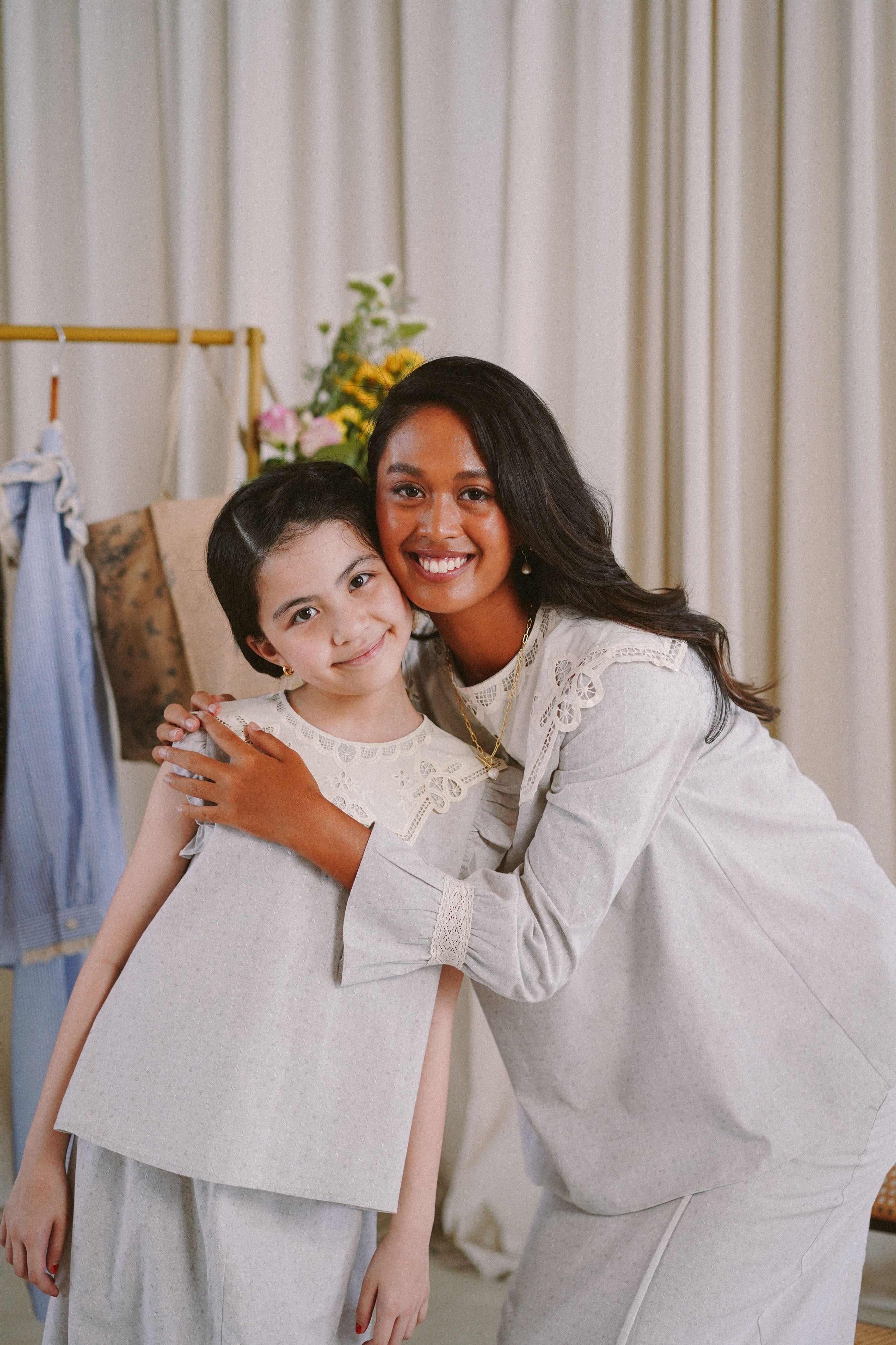 sisters wearing matching light blue dresses made by petit moi