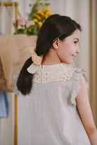 Back shot of little girl modelling in light blue dress made by petit moi