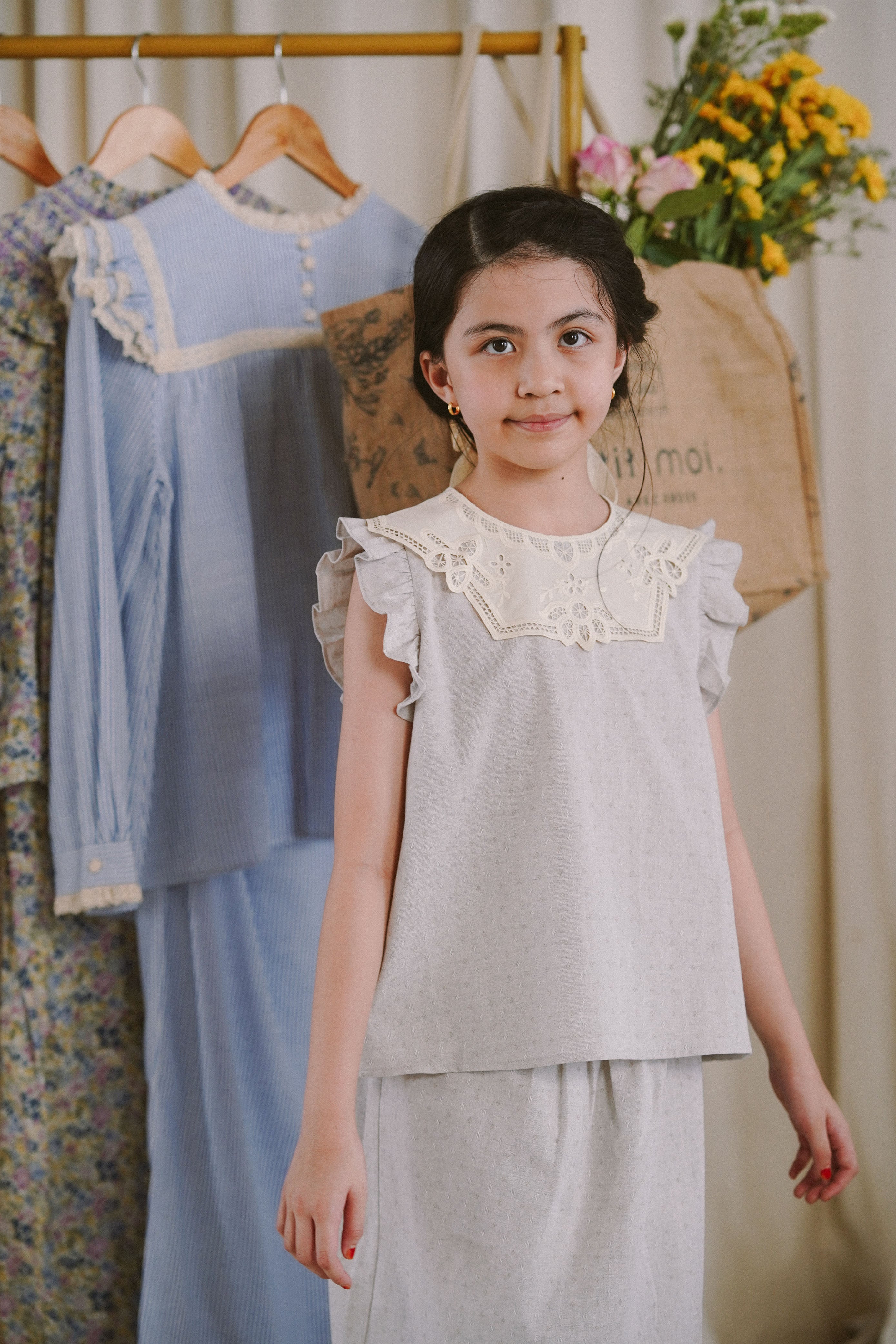 Happy girl smiling in her favourite light blue dress by petit moi