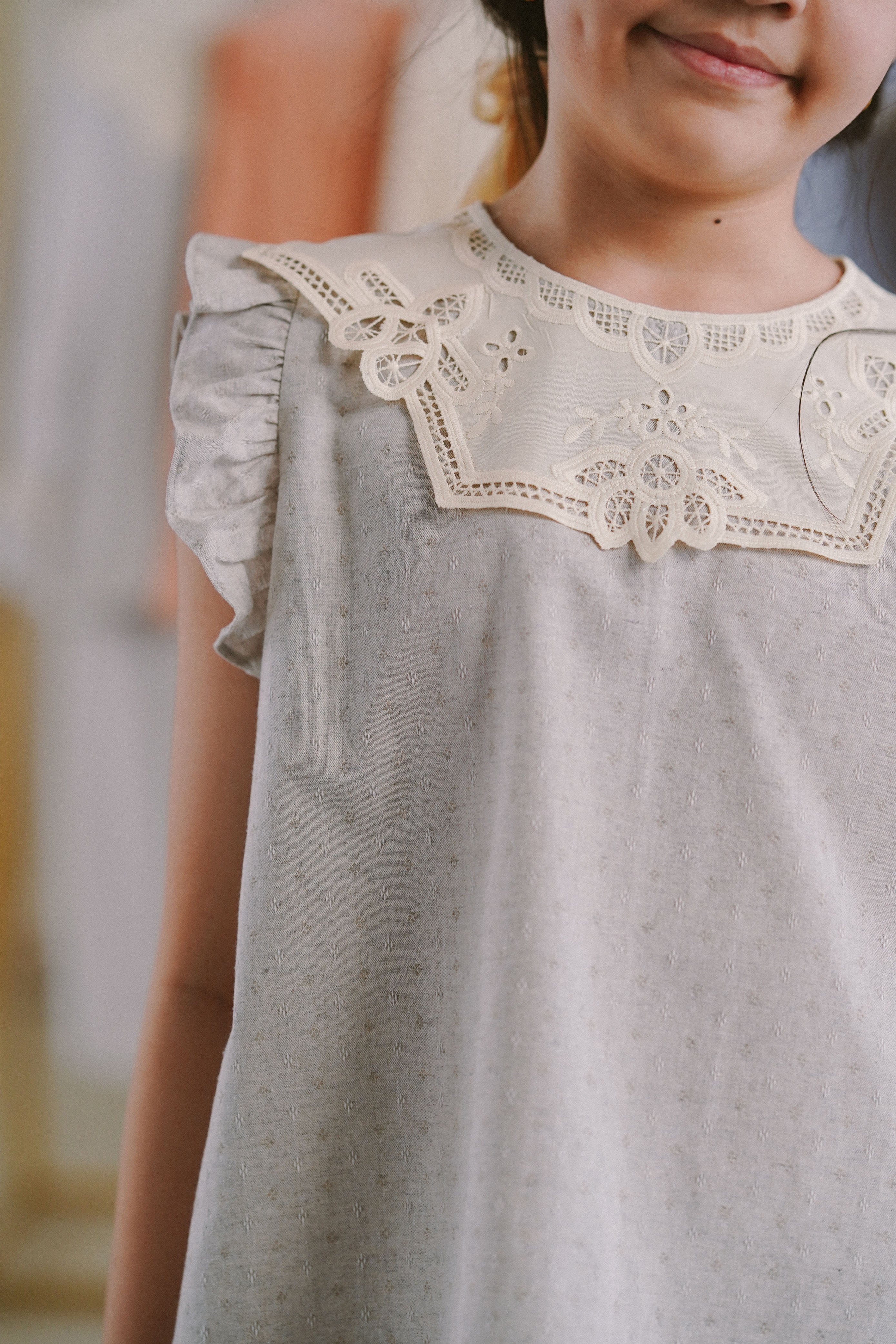 Closeup shot of little girl wearing light blue dress made by petit moi