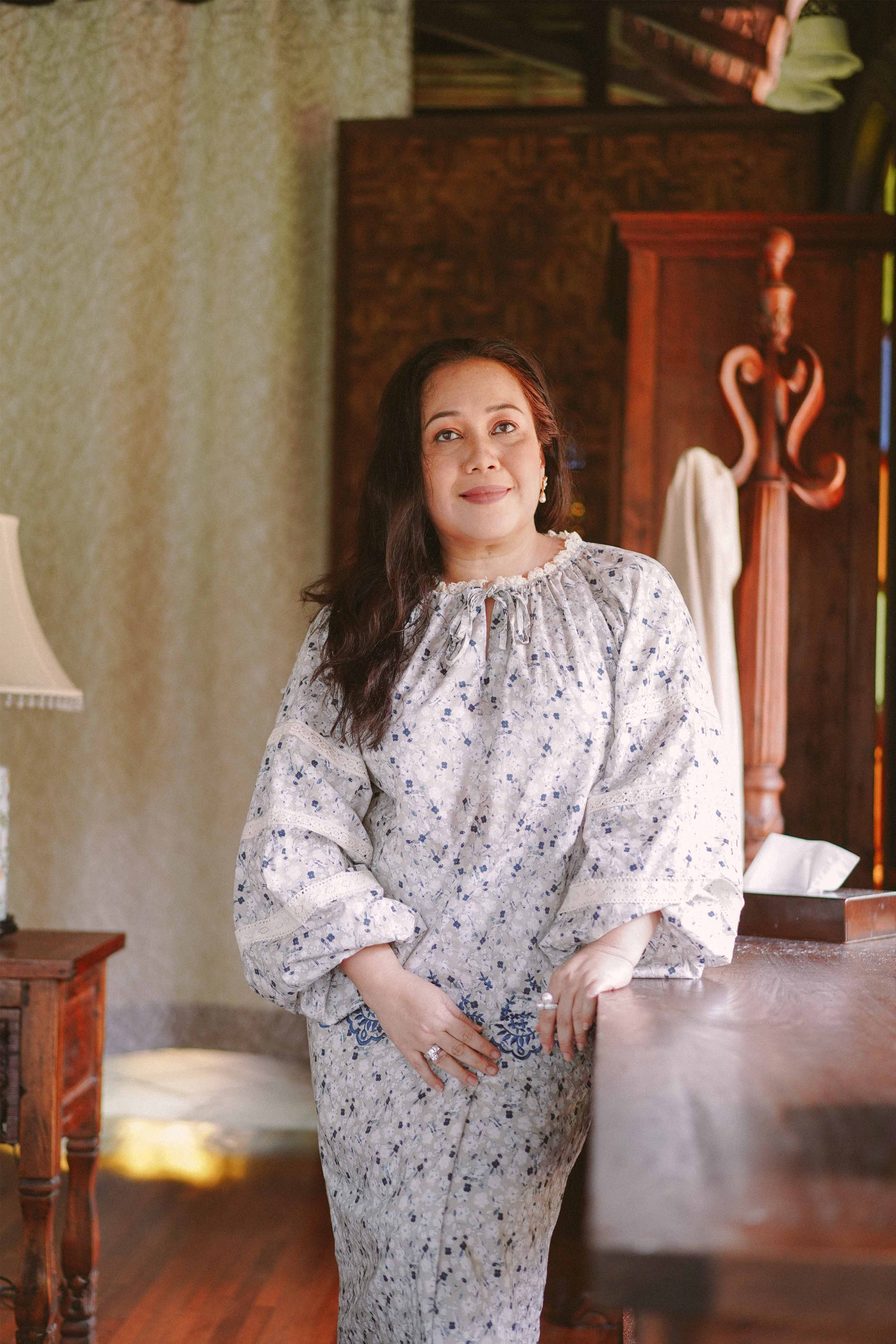 Mature woman in blue floral baju kurung made by petit moi