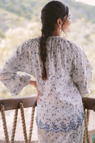 Back shot of female model wearing blue floral baju kurung