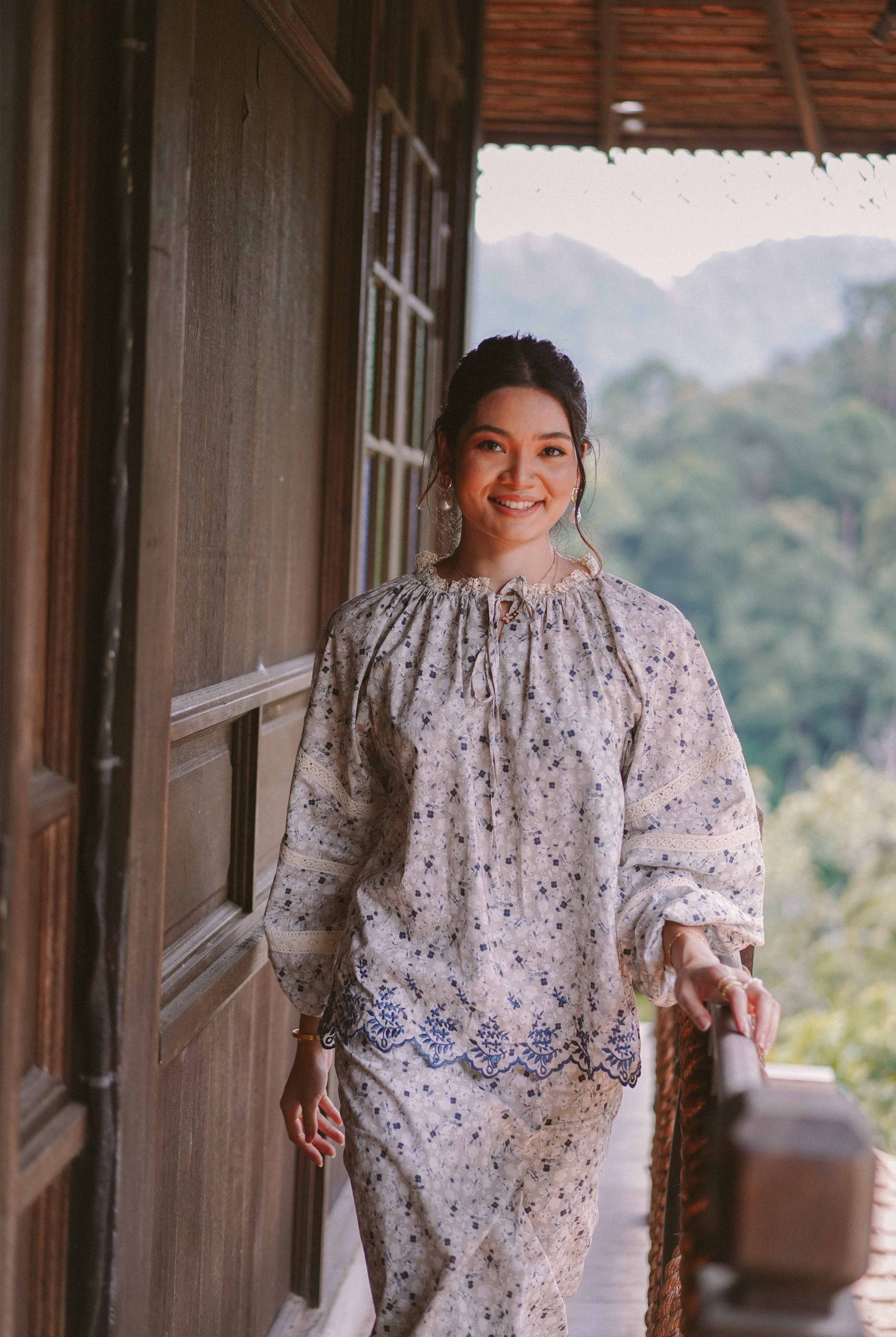 Female model posing in floral baju kurung made by petit moi