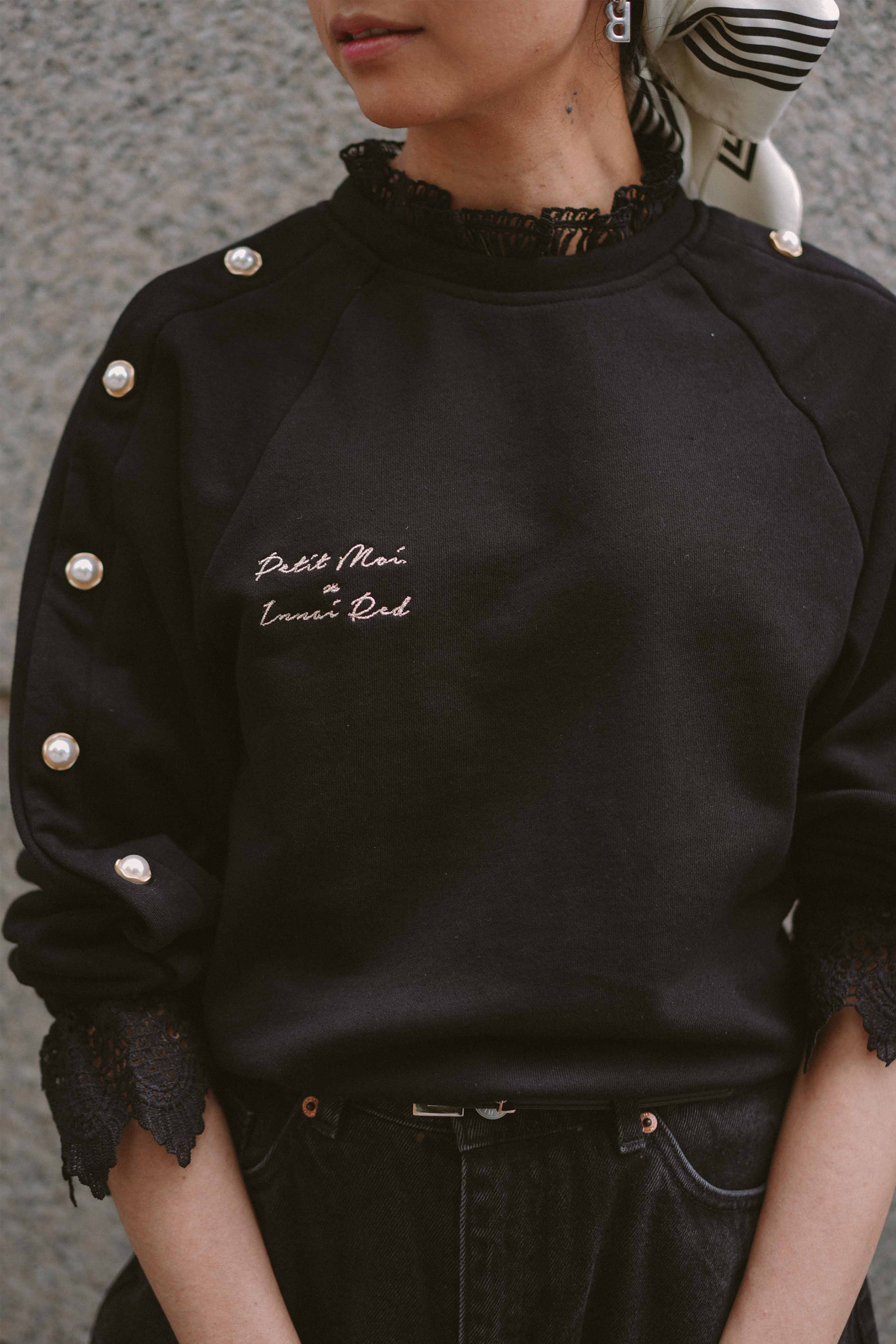 Front and closeup shot of black jumper by petit moi