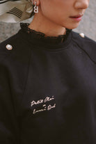 Closeup shot of female model wearing her favourite black jumper by petit moi