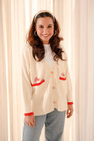 female model posing in a high quality white & red cardigan made by petit moi