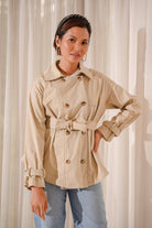 woman wearing high quality trench coat whilst posing for the camera
