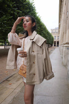 woman waiting for her cab wearing her high quality trench coat made by petit moi