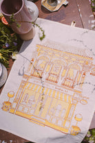petit moi yellow bingka tea towel and cup on table