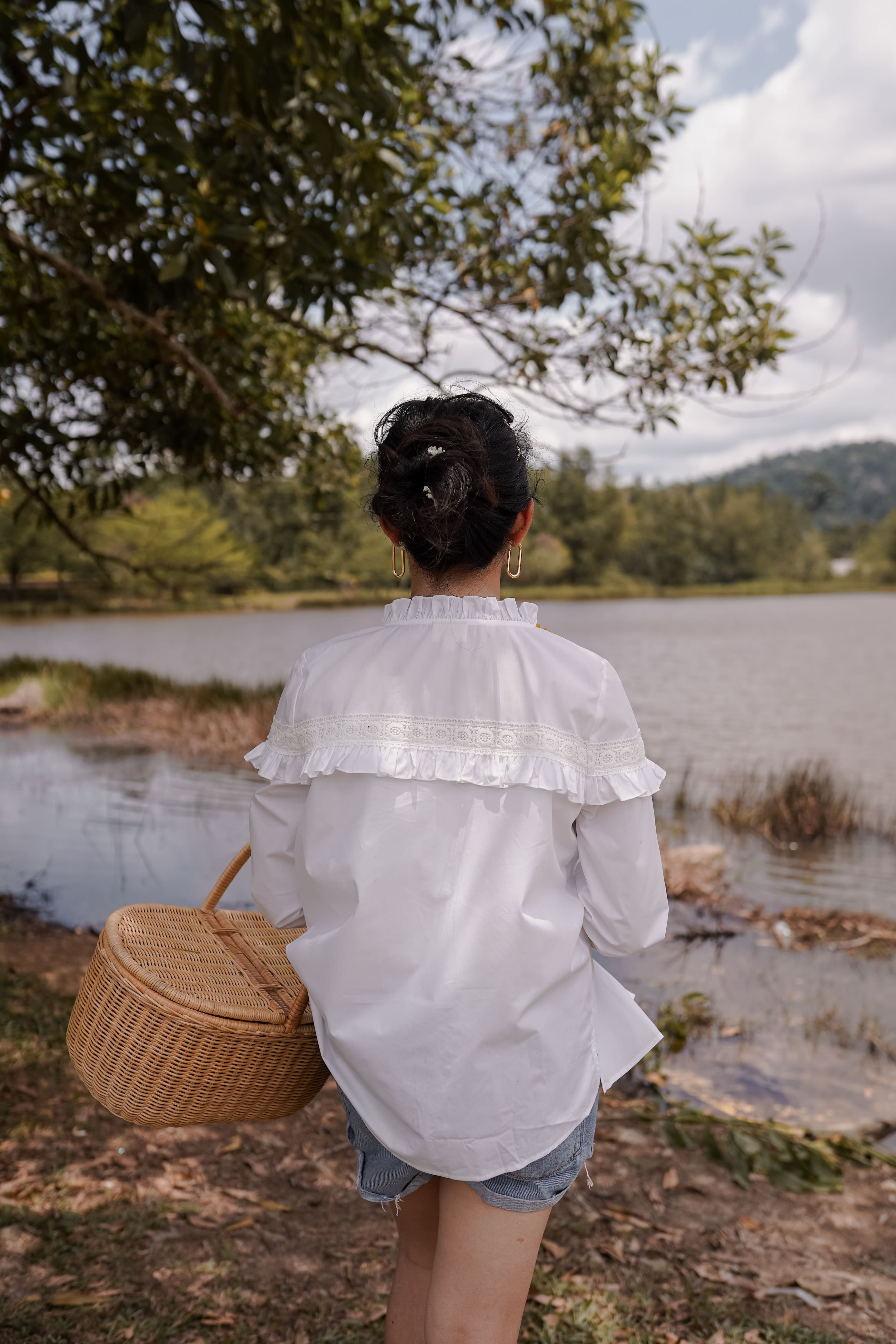 backshot of the lake and female model in white blouse made by petit moi
