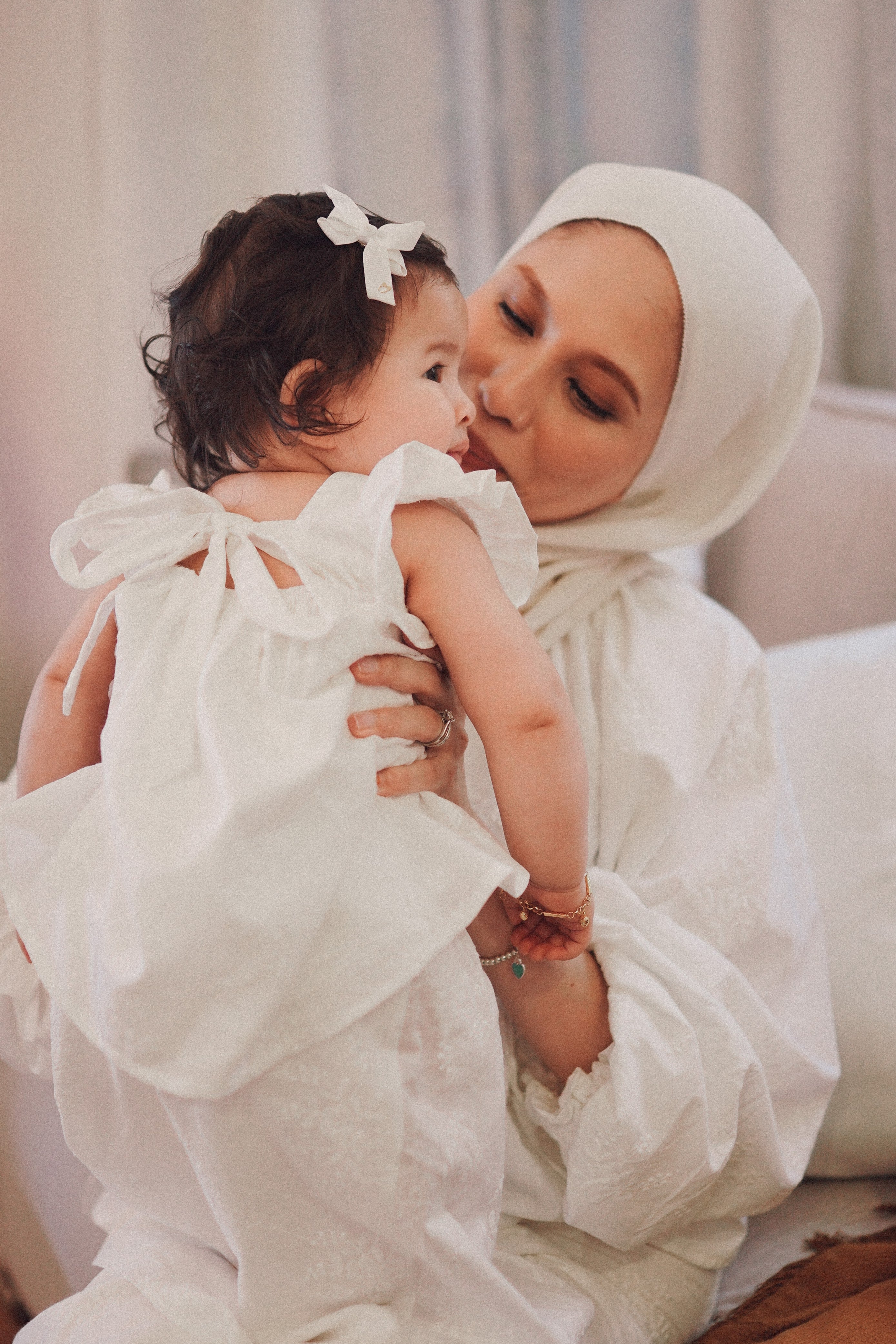 Mother and daughter wearing matching white clothes in picture