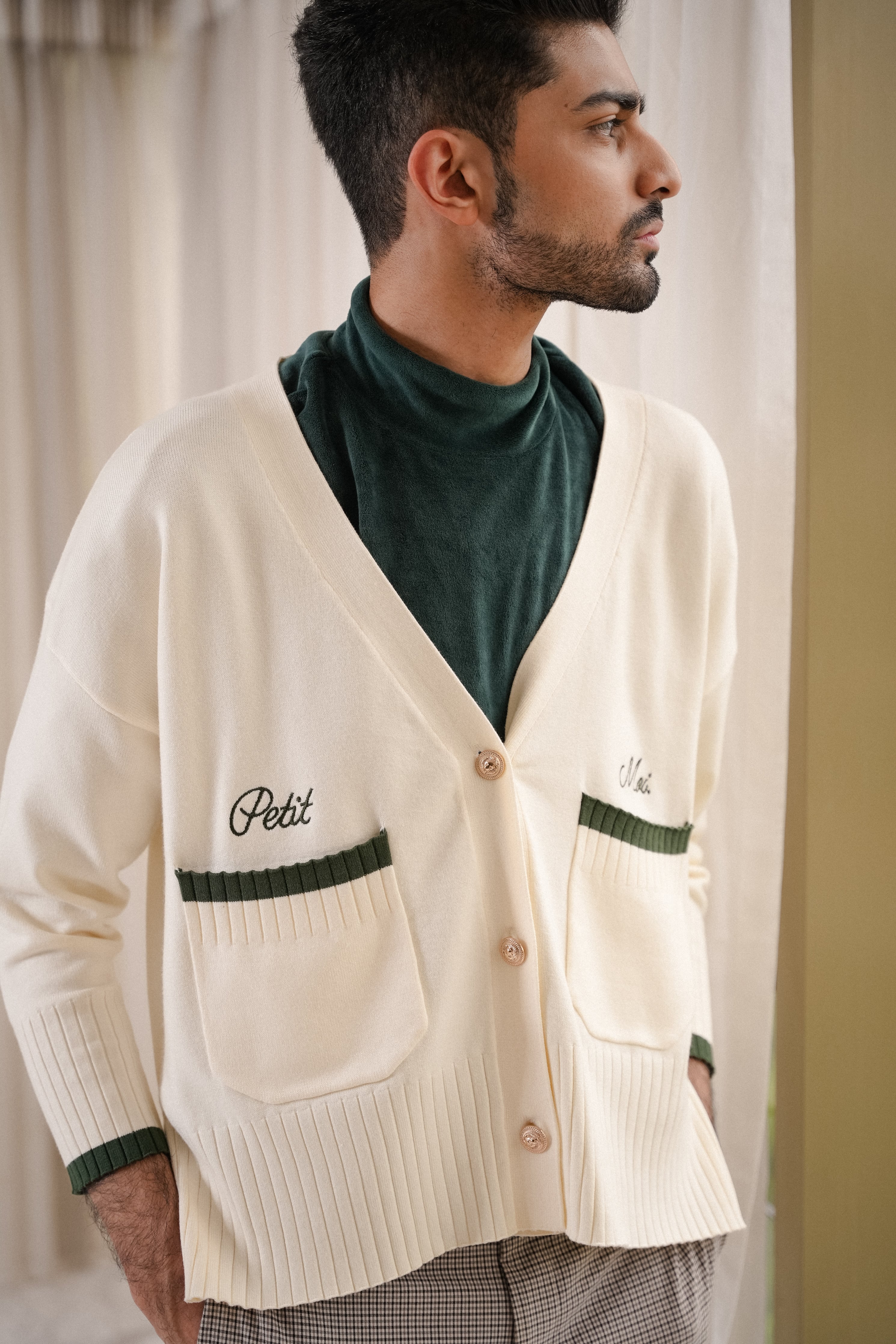 male model posing in high quality white and forest green cardigan made by petit moi