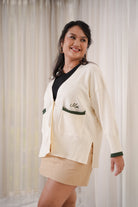 female model smiling happily in her new white and forest green cardigan by petit moi