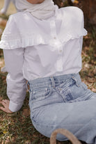 female model closeup shot wearing a white blouse made by petit moi