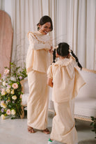 mother and daughter in candid shot wearing matching baju kurung by petit moi