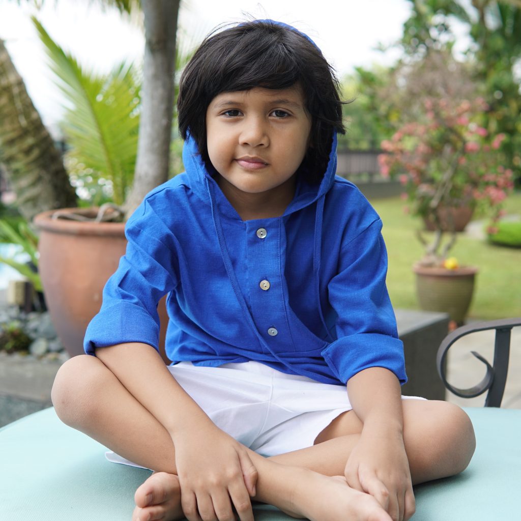little boy wearing blue hoodie shirt and sitting down 