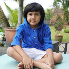 little boy wearing blue hoodie shirt and sitting down 