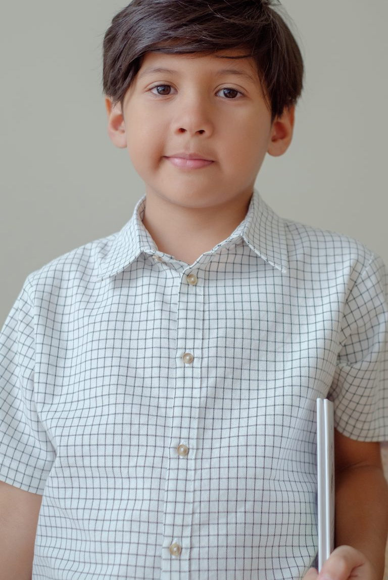 little boy in high quality white striped shirt made by petit moi