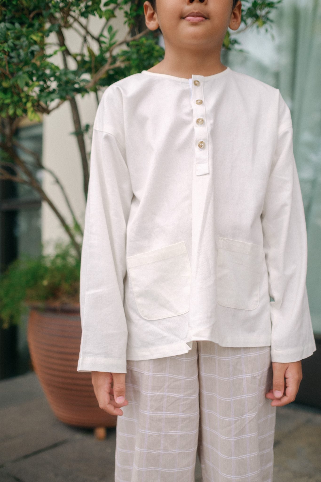 Boy in high quality modern kurta in white. Made by petit moi 