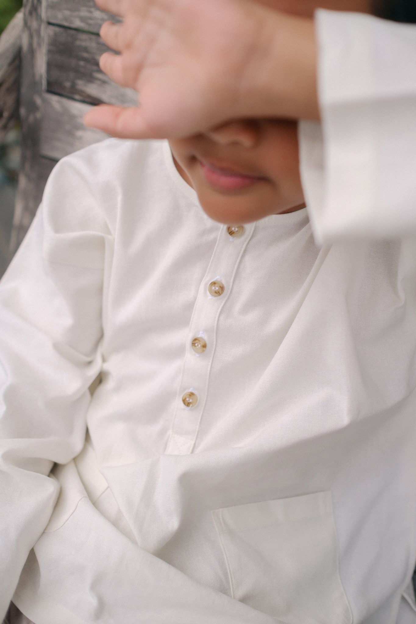 Closeup shot of little boy in high quality white modern kurta made by petit moi