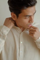 man in white kurta from Petit Moi looking at the side