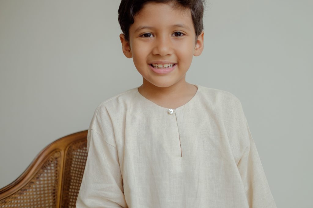 boy in white kurta smiling
