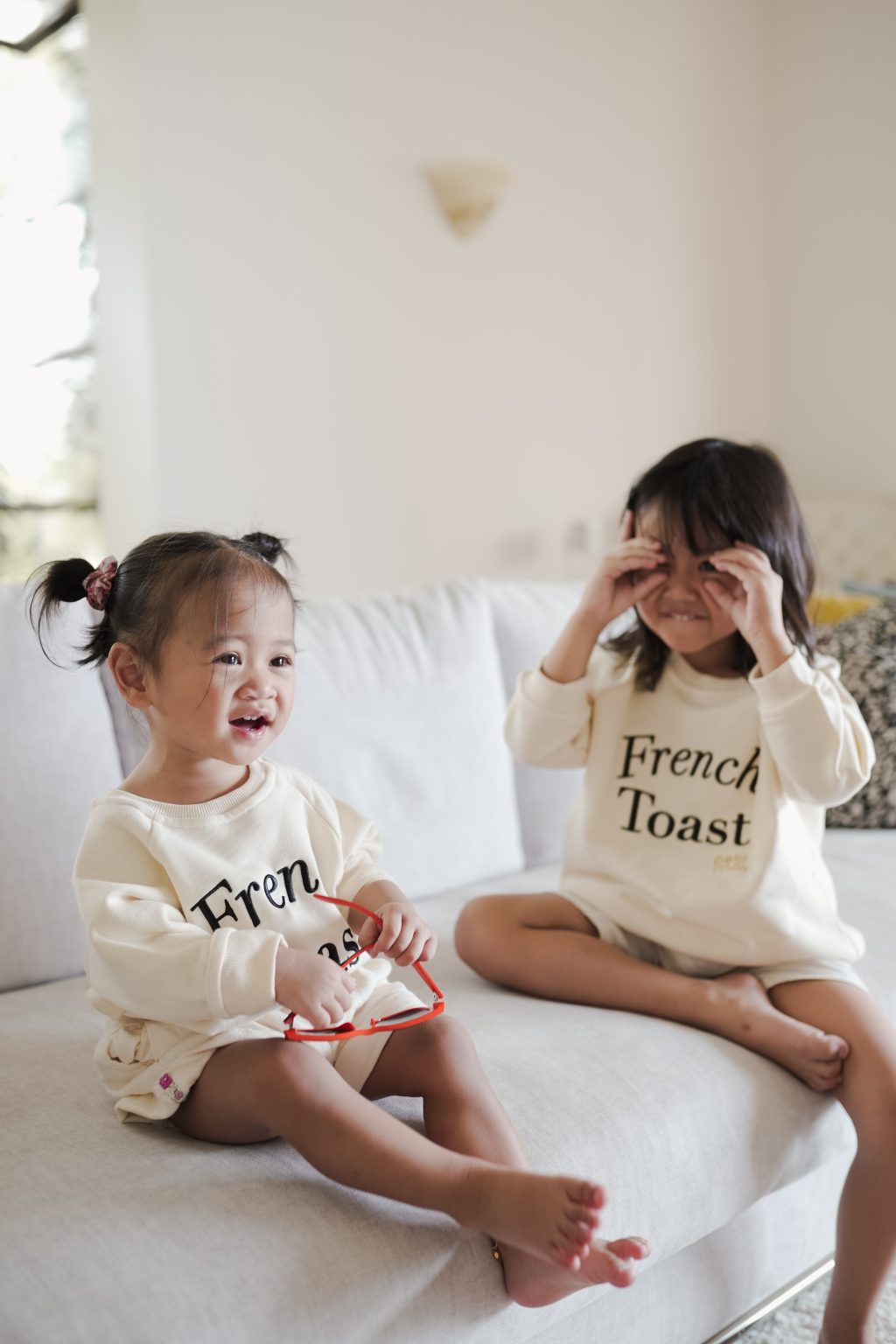 Little sisters in high quality matching sweaters made by petit moi