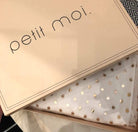 petit moi box on a table places with the dress below it