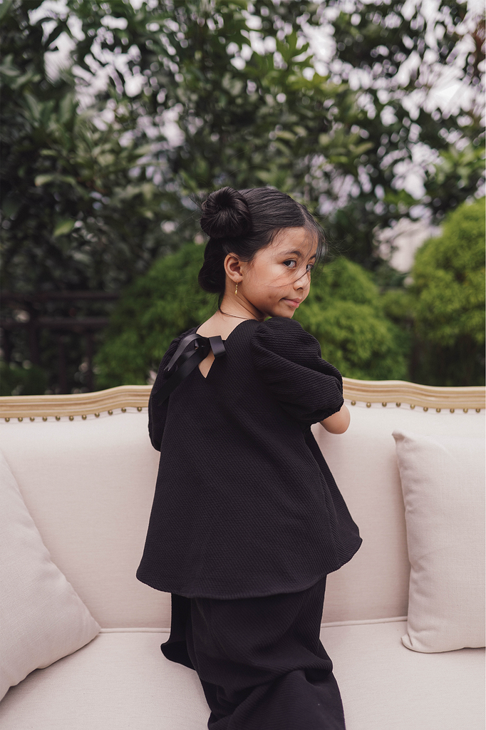 little girl model in black baju kurung made by petit moi
