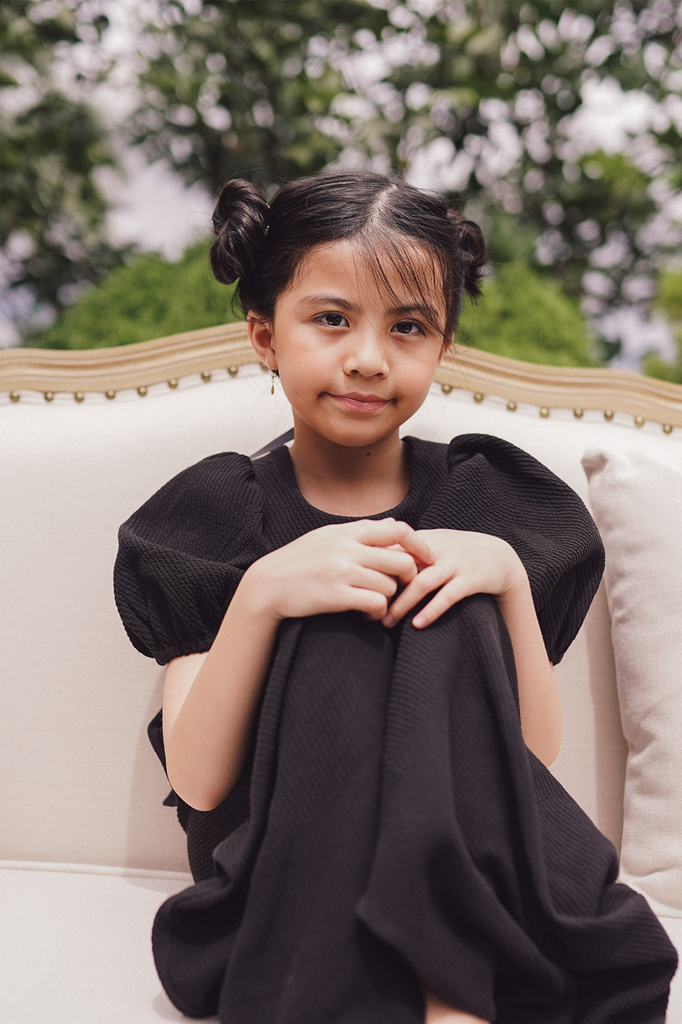little girl in black baju kurung made by petit moi