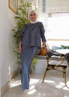 female model wearing comfortable navy floral baju kurung in her own home