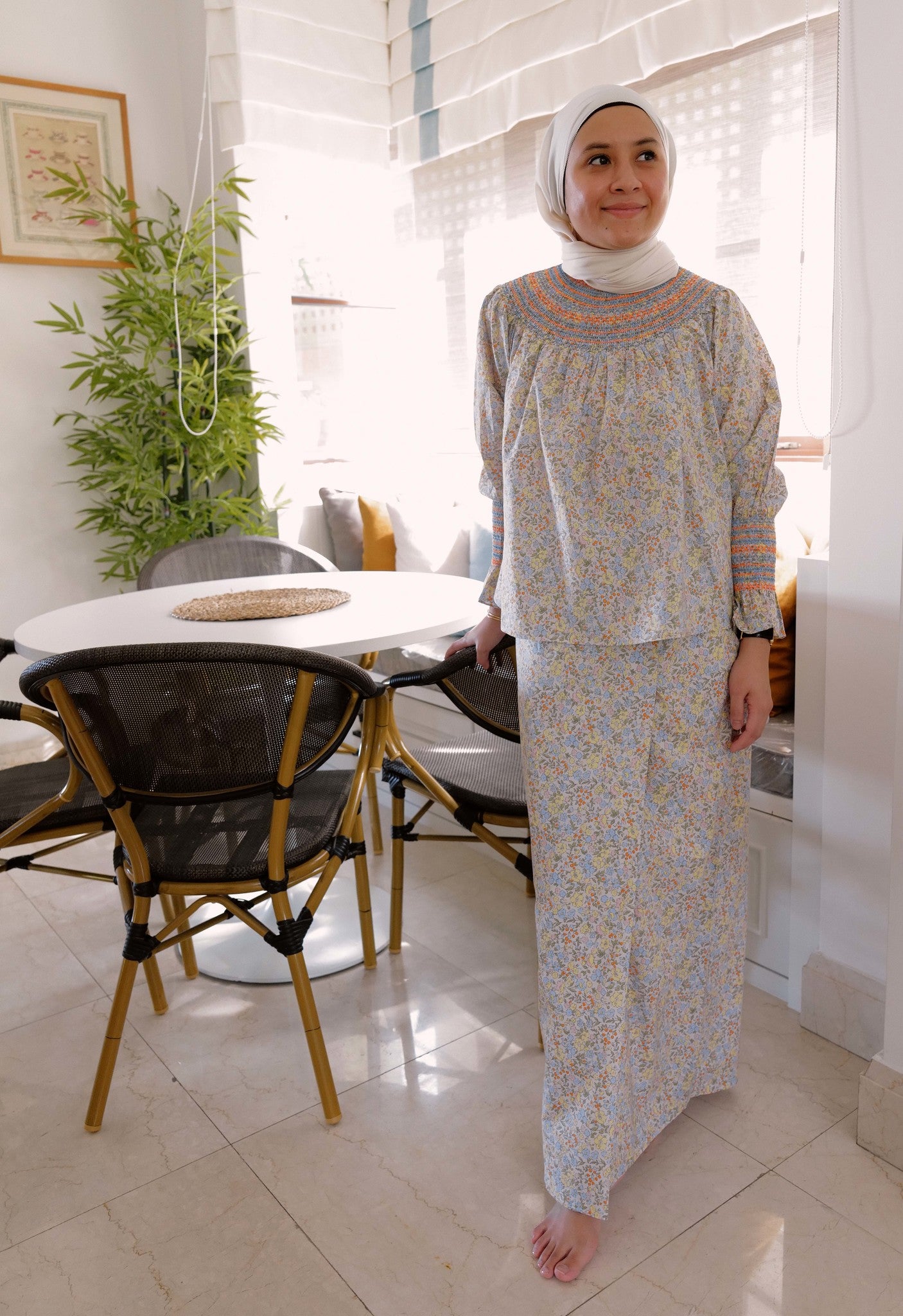Woman wearing comfortable and high quality baju kurung by petit moi. posing in her own kitchen