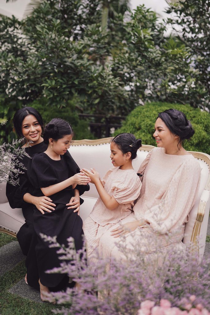 family photo of sisters wearing matching baju kurung made by petit moi