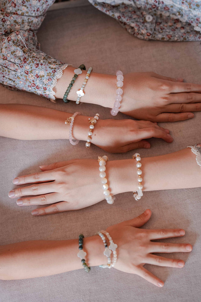 mother and daughters showing off their bracelets that were made by petit moi